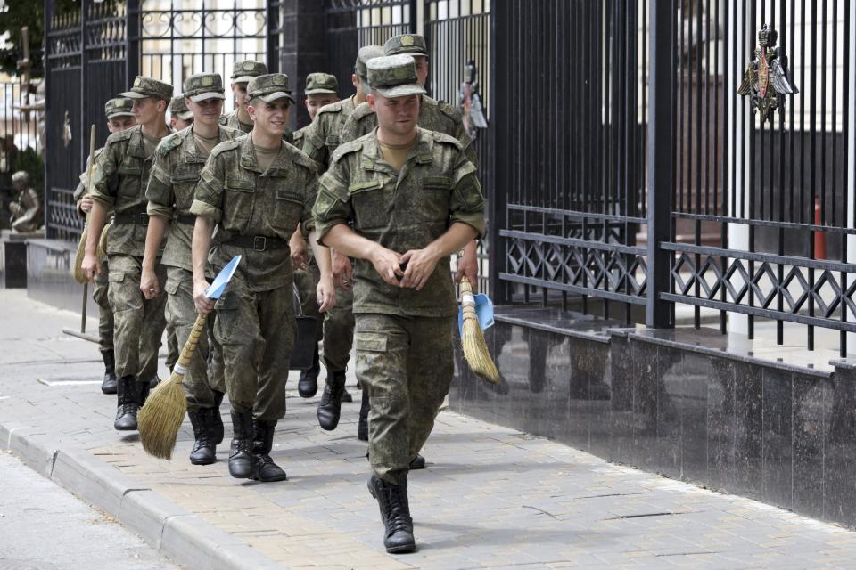FILE - Russian soldiers walk to clean the area at the headquarters of the Southern Military District in Rostov-on-Don, southern Russia, Sunday, June 25, 2023. The armed rebellion by a powerful mercenary group against the Russian military was over in less than 24 hours, but the disarray within the enemy’s ranks was an unexpected morale-boosting gift for Ukraine – at a time when its armed forces needed it the most. (AP Photo, File)