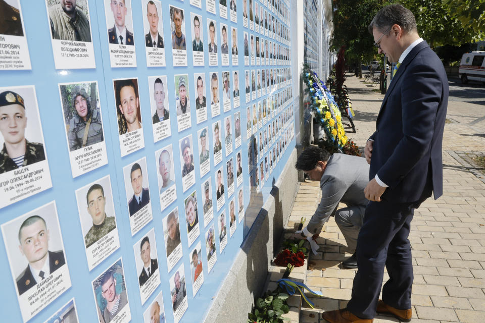 Ukraine's Foreign Minister Dmytro Kuleba, right, and his Japanese counterpart Yoshimasa Hayashi pay a visit to the Memory Wall of Fallen Defenders of Ukraine in Kyiv, Ukraine, Saturday, Sept. 9, 2023. Japanese Foreign Minister Hayashi arrived in Ukraine's capital for an unannounced visit where he will meet with top Ukrainian officials. (Sergey Dolzhenko/pool via AP)