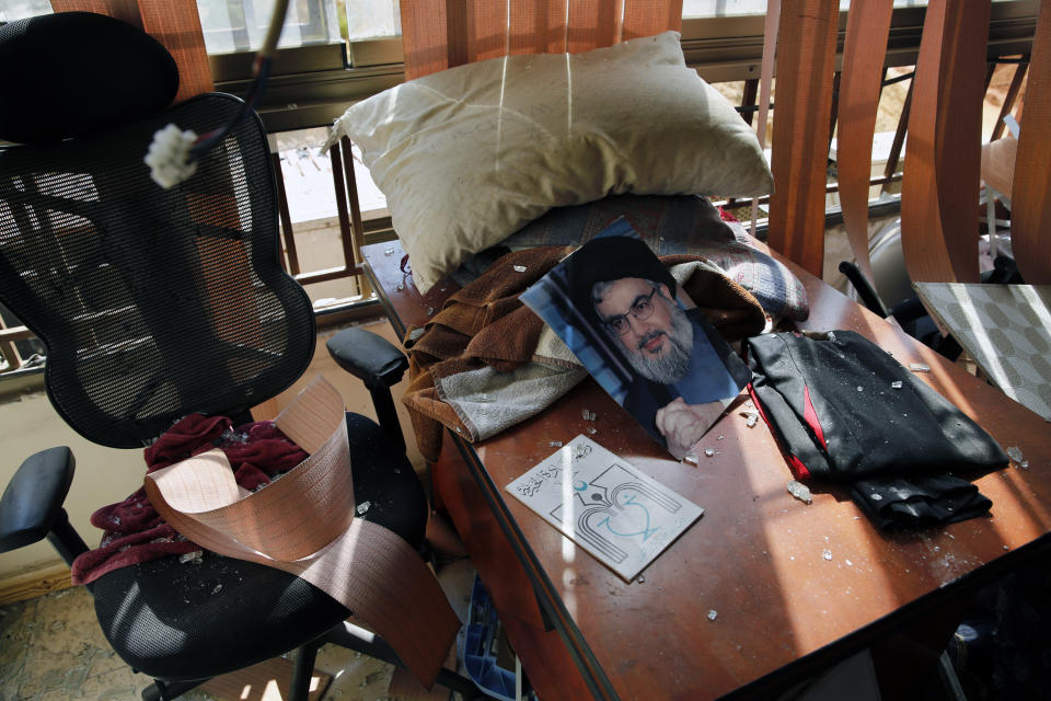 A poster of Hezbollah leader Sayyed Hassan Nasrallah is seen amid other damage inside the media office in a stronghold of the Lebanese Hezbollah group in a southern suburb of Beirut, Lebanon, Sunday, Aug. 25, 2019. Two Israeli drones crashed in a Hezbollah stronghold in the Lebanese capital overnight without the militants firing on them, a spokesman for the group said Sunday, saying the first fell on the roof of a building housing Hezbollah's media office while the second landed in a plot behind it. (AP Photo/Bilal Hussein)