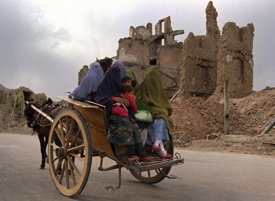 FILE -- In this Oct. 8, 1996 file photo, a horsecart carries a group of women with children to the market through a war-ruined section of Kabul. The Taliban fighters who rolled into Afghanistan's capital and other cities in recent days appear awestruck by the towering apartment blocks, modern office buildings and shopping malls. When the Taliban last seized power, in 1996, the country had been ravaged by civil war and the capital was in ruins. (AP Photo/John Moore, File)
