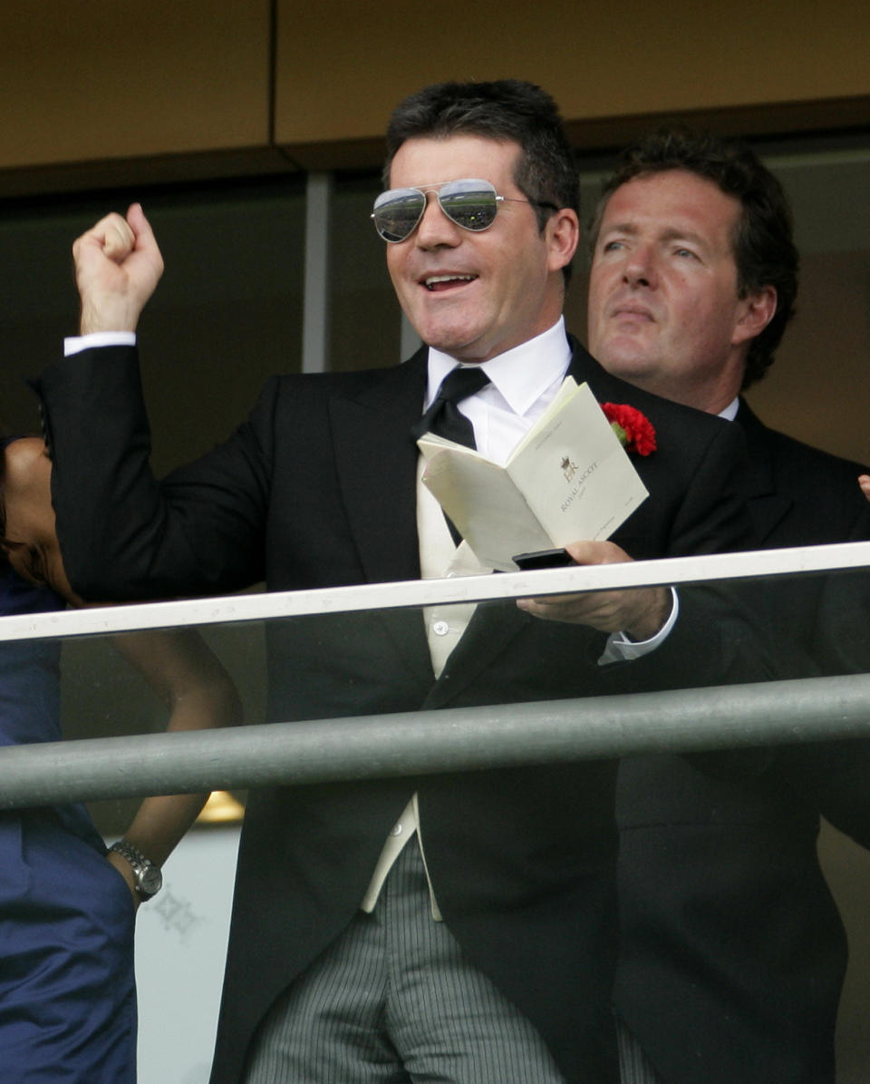 ASCOT, UNITED KINGDOM – JUNE 17: Simon Cowell cheers whilst watching the racing with Piers Morgan on a balcony in Ascot, England. (Photo by Indigo/Getty Images)