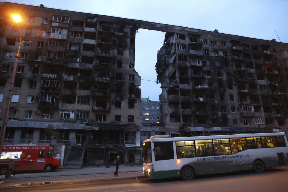 FILE - A bus stops in front of an apartment building damaged during a heavy fighting in Mariupol, Donetsk People's Republic, Ukraine, Friday, Nov. 4, 2022. (AP Photo/Alexei Alexandrov, File)