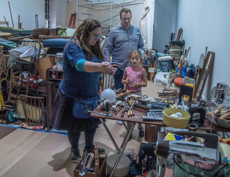 La artista Kerry Phillips guía a Olivia Gora y a su padre, Jan Gora, de Miami, a través de los objetos que ha ido coleccionando a lo largo de los años mientras invita a los visitantes a observarla e interactuar con ella mientras construye la instalación de la pieza de su próxima exposición individual titulada "Kerry Phillips: Between the Mundane and the Miraculous" en The Bass Museum, en Miami Beach, que abrirá el 17 de agosto. el viernes 4 de agosto de 2023.