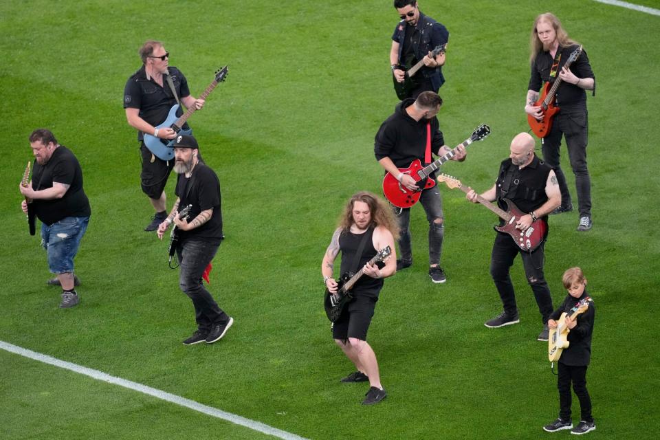 Performers hold guitars during the opening ceremony ahead of the Europa Conference League final soccer match between Fiorentina and West Ham - AP Photo/Darko Vojinovic