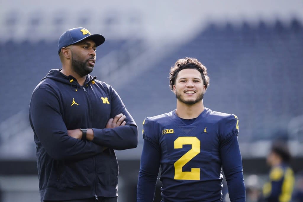 Michigan offensive coordinator Sherrone Moore, left, speaks with running back Blake Corum during NCAA college football practice Saturday, Dec. 30, 2023, in Inglewood, Calif. (AP Photo/Ryan Sun)