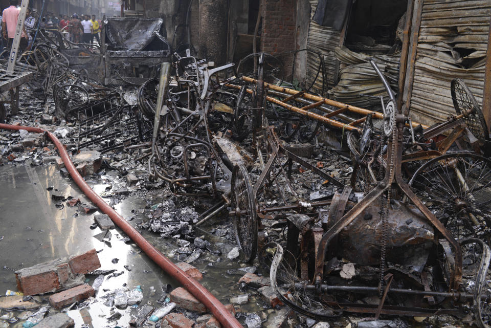 The wrangled and charred remains of rickshaws lie at the site of a late Wednesday night fire in Dhaka, Bangladesh, Thursday, Feb. 21, 2019. A devastating fire raced through at least five buildings in an old part of Bangladesh's capital and killed scores of people. (AP Photo/Mahmud Hossain Opu )