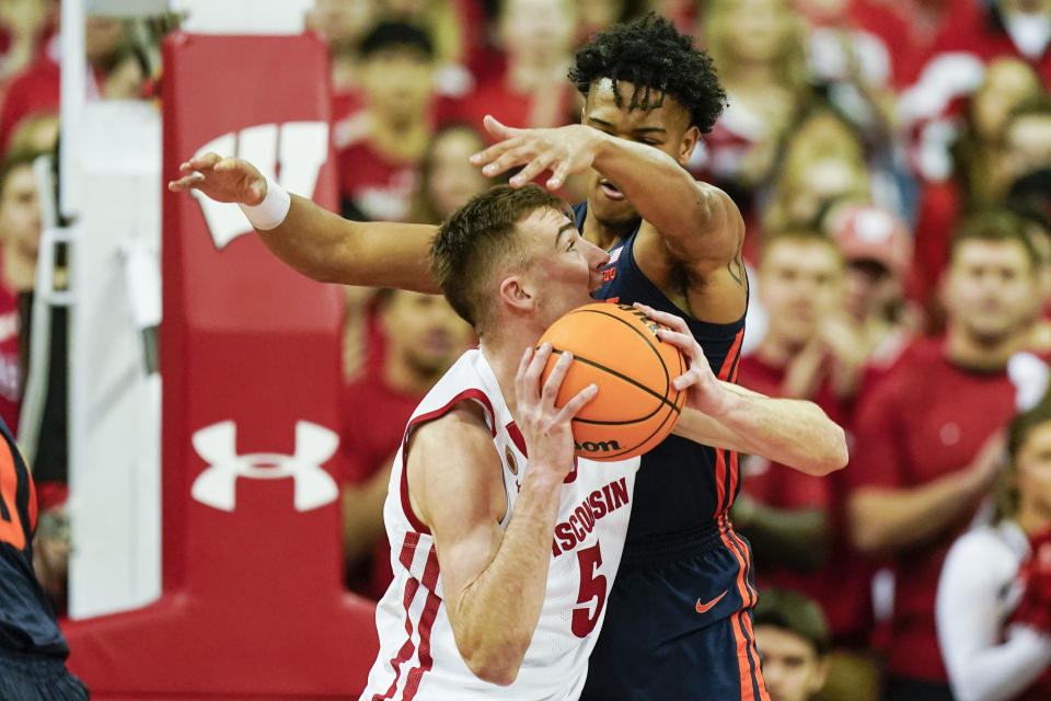 Illinois's Ty Rodgers, behind, fouls Wisconsin's Tyler Wahl (5) during the first half of an NCAA college basketball game Saturday, Jan. 28, 2023, in Madison, Wis. (AP Photo/Andy Manis)