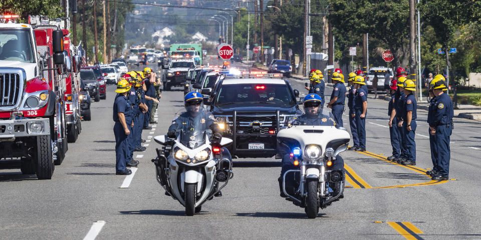 The California Highway Patrol leads the procession along with U.S. Forest Service vehicles as they escort fallen firefighter Charles Morton, killed while battling a blaze in the mountains east of Los Angeles, along Hewes Street in Orange, Calif., Tuesday, Sept. 22, 2020, from San Bernardino to the Ferrara Colonial Mortuary in Orange. Morton, 39, a San Diego native, was a 14-year veteran of the U.S. Forest Service and a squad boss for the Big Bear Interagency Hotshots in San Bernardino National Forest, officials said. (Mark Rightmire/The Orange County Register via AP)