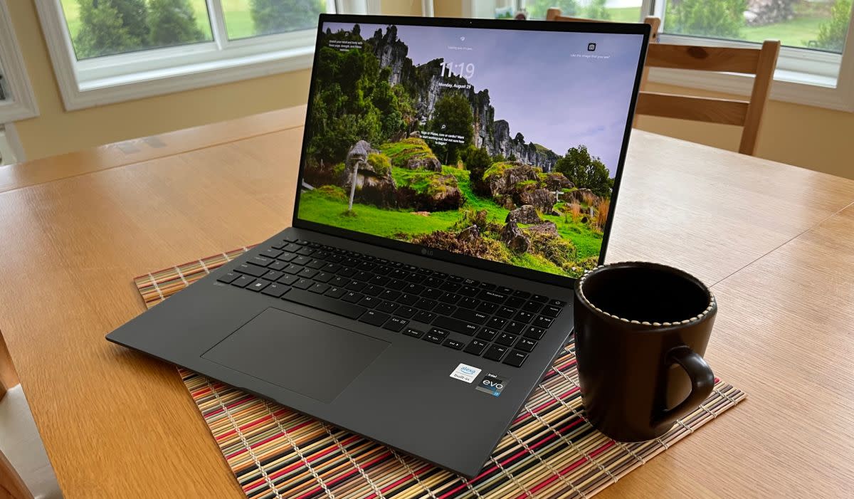 Laptop on a table next to a mug