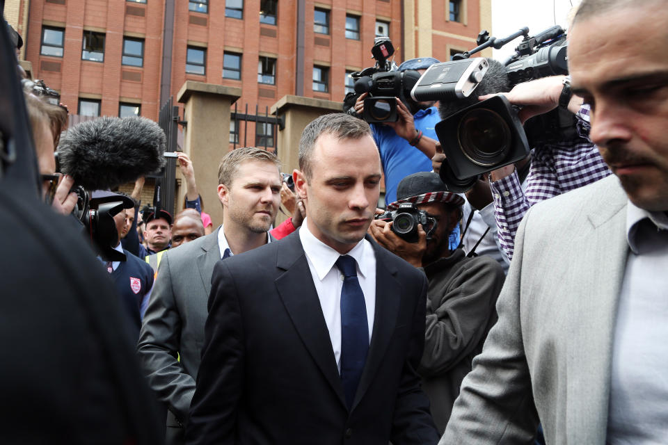 Oscar Pistorius, center, leaves the high court in Pretoria, South Africa, Tuesday, April 15, 2014. Pistorius is charged with murder for the shooting death of his girlfriend, Reeva Steenkamp, on Valentines Day in 2013. (AP Photo/Themba Hadebe)