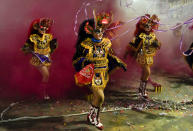 Andrea Hinojosa, center, dressed as devil perform the Diablada de Oruro" dances in Oruro, Bolivia, Friday, Oct. 1, 2021. Hinojosa says "It was difficult during the COVID-19 pandemic, I missed not being able to dance at the Oruro carnival, I remembered with nostalgia watching the videos of previous years how we danced, today the joy is back, we are dancing La Diablada again."(AP Photo/Juan Karita)