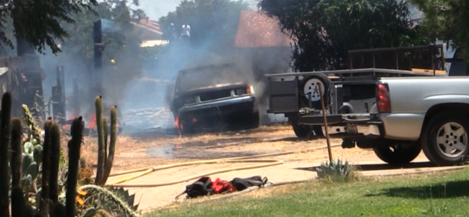 A car is burned after a grass fire spread east on Cornelia Avenue, between Clinton and McKinley avenues in Fresno, California on Thursday, June 6, 2024.