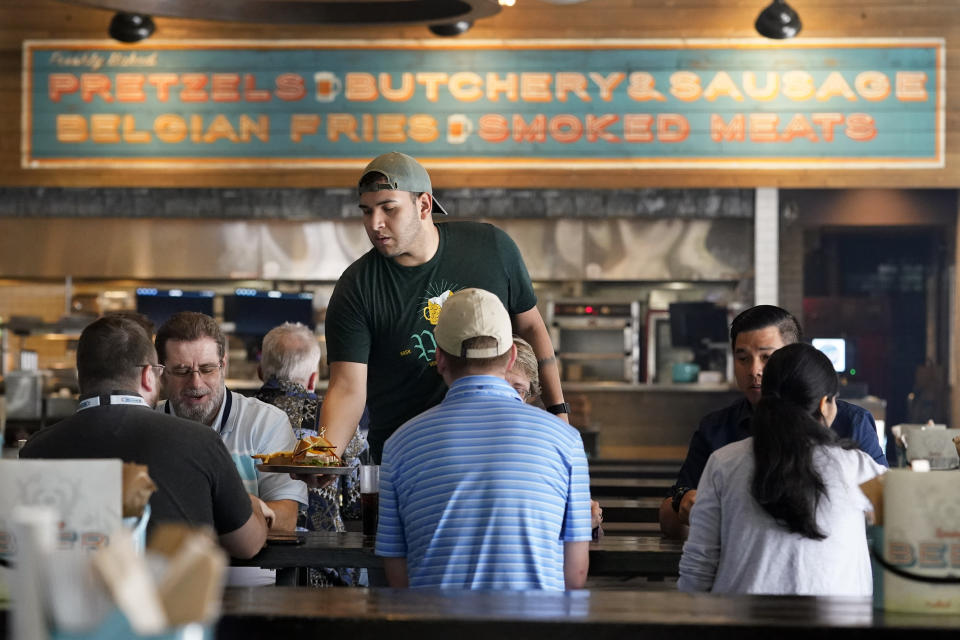 David Rodriguez serves customers at Von Elrod's Beer Hall And Kitchen June 7, 2022, in Nashville, Tenn. For the restaurant, located across the street from Nashville's minor league baseball stadium that sees big crowds in the summer, both inflation and the worker shortage have sent costs skyrocketing. Small businesses that depend on summer crowds and tourism are hoping for a bustling summer this year, boosted by pent up demand after more than two years of the pandemic. (AP Photo/Mark Humphrey)