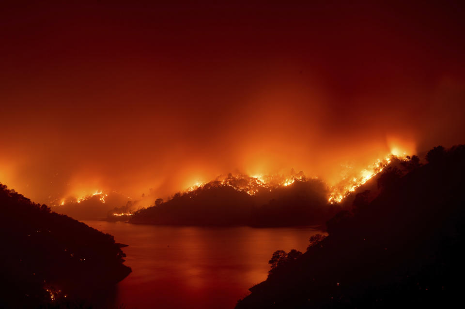 Flames from the LNU Lightning Complex fires burn around Lake Berryessa in unincorporated Napa County, Calif., on Wednesday, Aug. 19, 2020. Fire crews across the region scrambled to contain dozens of wildfires sparked by lightning strikes. (AP Photo/Noah Berger)