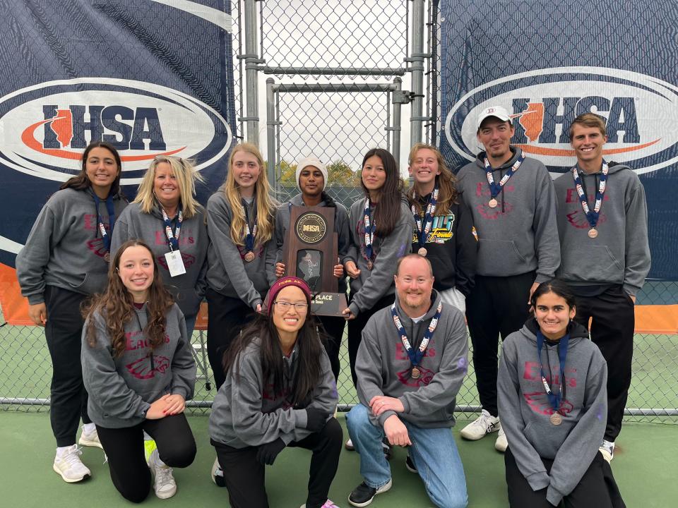 The Dunlap High School girls tennis players and coaching staff celebrate with the third-place trophy after the school secured its highest-ever finish in the Class 1A IHSA State Finals tennis tournament on Saturday, Oct. 21, 2023 at Buffalo Grove.