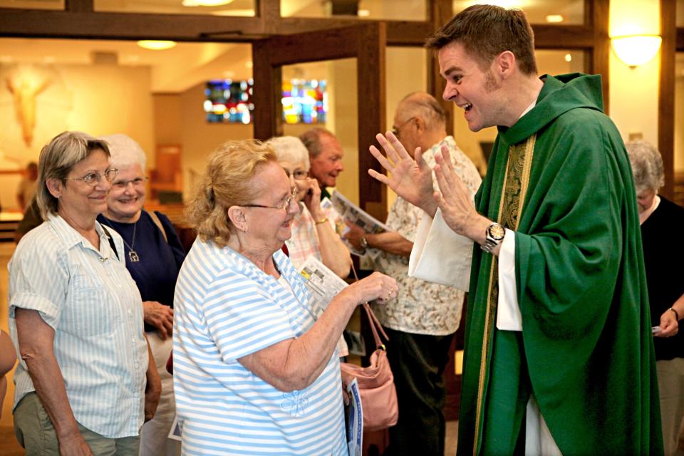 In this photo from July 16, 2011, soon after he was ordained, the Rev. Christopher Klusman greets parishioner Lila Dye, center, after Mass at St. Roman Parish in Milwaukee.