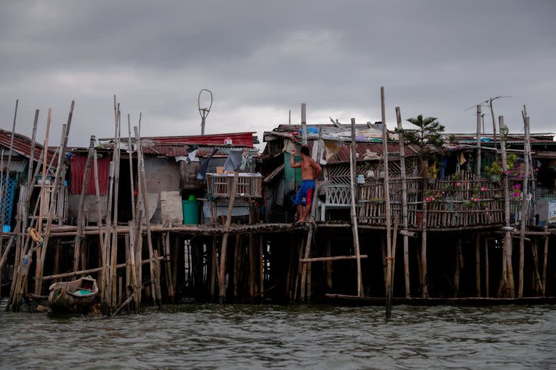 The Wider Image: Rising seas threaten early end for sinking village in Philippines