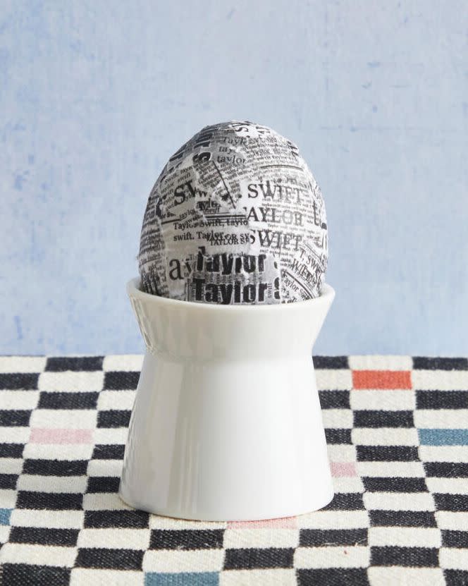 an easter egg decorated with newspaper clippings for taylor swift's reputation album