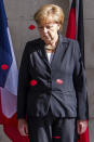 FILE - In this June 26, 2014 file photo, German Chancellor Angela Merkel watches paper poppies fall at the Menin Gate in Ypres, Belgium. German Chancellor Angela Merkel will mark the 100th anniversary of the end of World War I on French soil, and President Frank-Walter Steinmeier will be in London’s Westminster Abbey for a ceremony with the queen. But in Germany, there are no national commemorations planned for the centenary of the Nov. 11 armistice that brought an end to the bloody conflict that killed more than 2 million of its troops and left 4 million wounded. That’s because the armistice did not bring peace to Germany. (AP Photo/Geert Vanden Wijngaert, File)