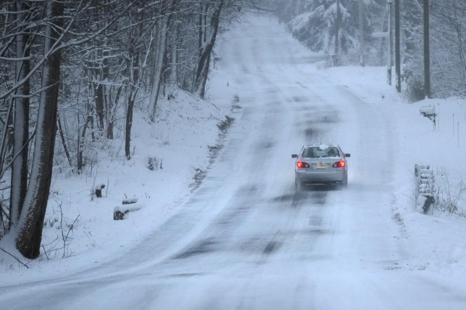 A car treks down a snow covered road, Sunday, Jan. 7, 2024, in Derry, N.H. Some areas of New England are expected to receive about a foot of snow from a winter storm. (AP Photo/Charles Krupa)