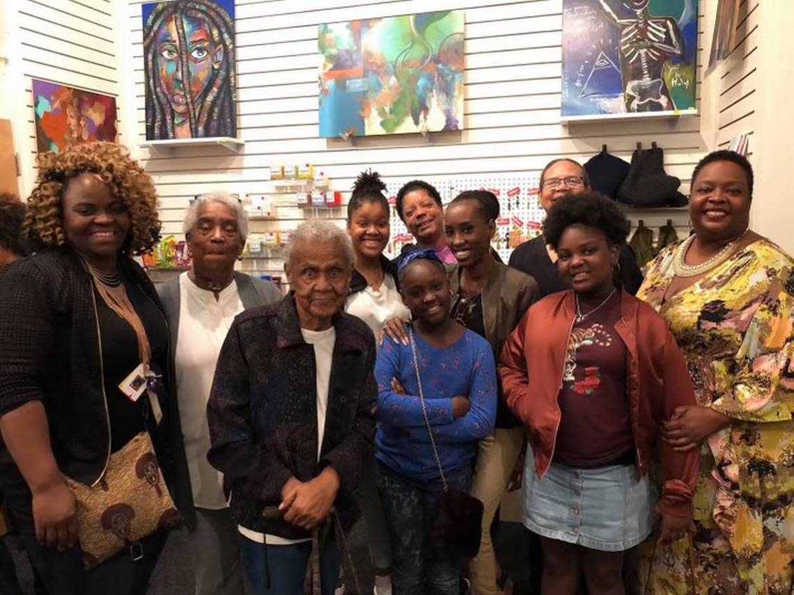 Juanita Gibson seen at an art show with her work and five generations of decendants.
