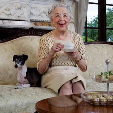 Senior-woman-sitting-on-sofa-with-dogs_web