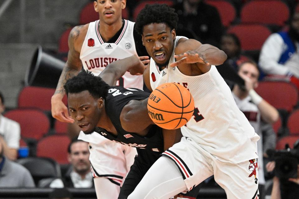 November 26, 2023;  Louisville, Kentucky, USA;  Louisville Cardinals forward Emmanuel Okorafor (34) faces New Mexico State Aggies forward Kaosi Ezeagu (1) for the ball