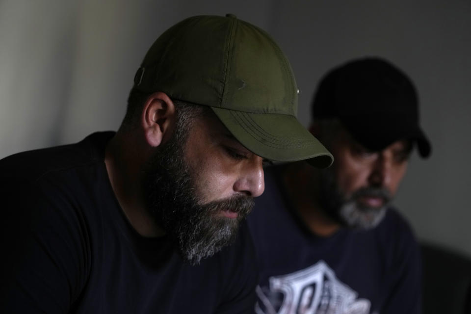 Amid Dandashi, left, and his brother Bilal gesture during an interview with the Associated Press, in Tripoli, Lebanon, Wednesday, April 27, 2022. A week ago, the boat carrying Bilal and his brother Amid, their relatives and dozens of others hoping to escape Lebanon and reach Europe sank in the Mediterranean. (AP Photo/Hassan Ammar)