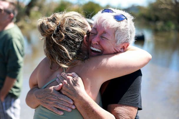 PHOTO: Sue Lepisto hugs her neighbor after they saw each other while visiting their homes, which were flooded by six feet of water, following Hurricane Ian, Sept. 30, 2022, in Fort Myers, Fla. (Joe Raedle/Getty Images)