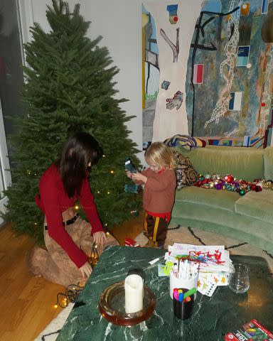 <p>Emily Ratajkowski/Instagram</p> Emily Ratajkowski and Sly untangling lights for the Christmas tree