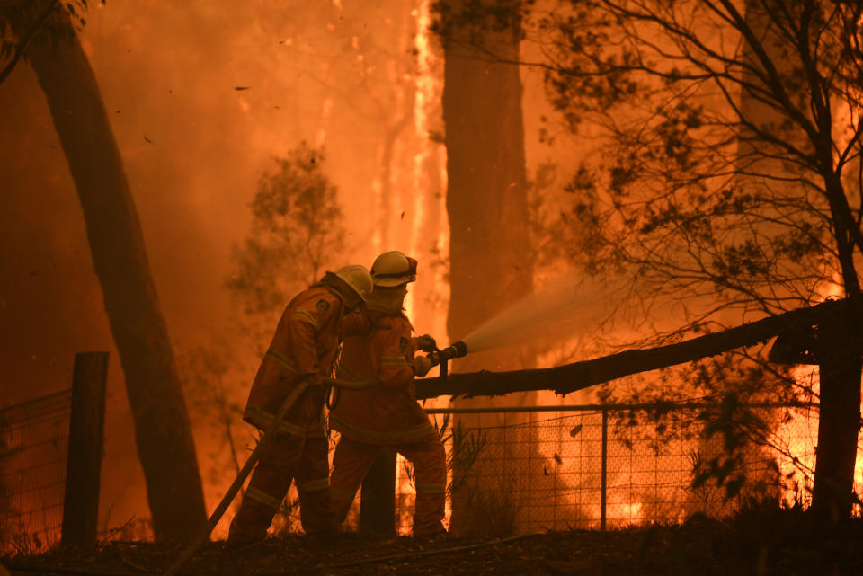 RFS volunteers and NSW Fire and Rescue officers protect a home on Wheelbarrow Ridge Road being impacted by the Gospers Mountain fire near Colo Heights southwest of Sydney.