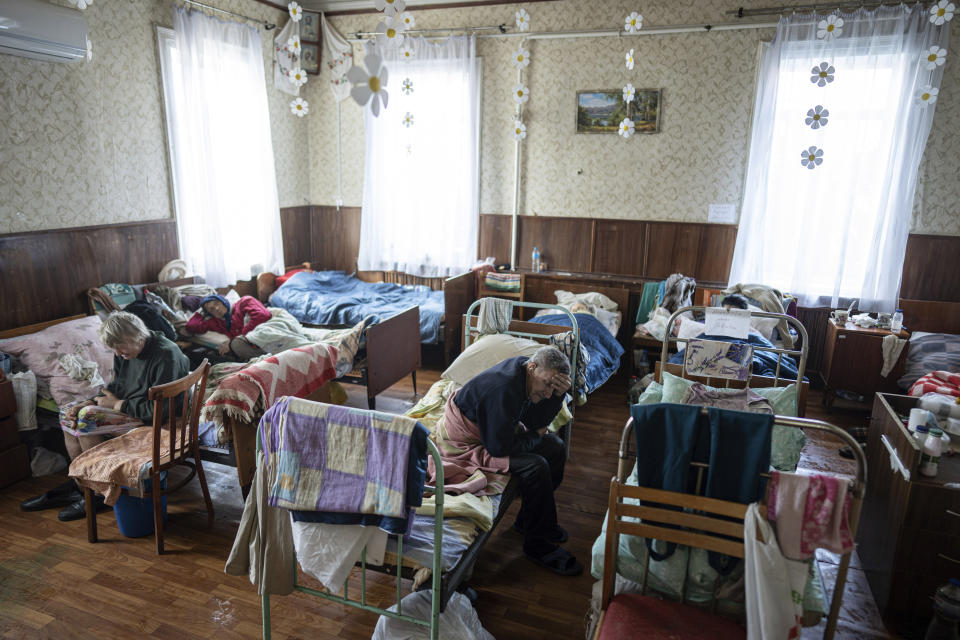 Patients rest in a shelter for injured and homeless people in Izium, Ukraine, Monday, Sept. 26, 2022. A young Ukrainian boy with disabilities, 13-year-old Bohdan, is now an orphan after his father, Mykola Svyryd, was taken by cancer in the devastated eastern city of Izium. (AP Photo/Evgeniy Maloletka)