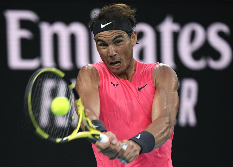 FILE - In this Jan. 29, 2020, file photo, Spain's Rafael Nadal makes a backhand return to Austria's Dominic Thiem during their quarterfinal match at the Australian Open tennis championship in Melbourne, Australia. No. 2 Rafael Nada – Seeks his 21st Grand Slam singles title, which would break a tie with Roger Federer for the most won by a man. (AP Photo/Andy Brownbill, File)