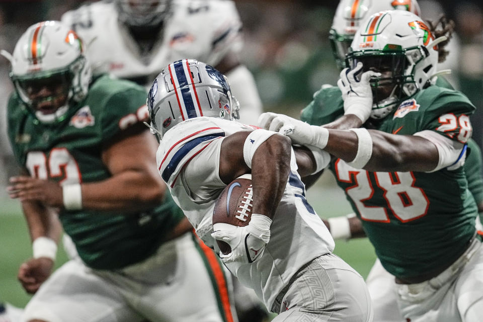 Howard running back Eden James (5) runs against Florida A&M linebacker Johnny Chaney Jr. (28) during the first half of an NCAA Celebration Bowl football game, Saturday, Dec. 16, 2023, in Atlanta. (AP Photo/Mike Stewart)