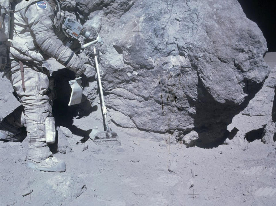 Apollo 16 astronaut Charlie Duke collects lunar samples during a moonwalk. <cite>NASA/Johnson Space Center</cite>