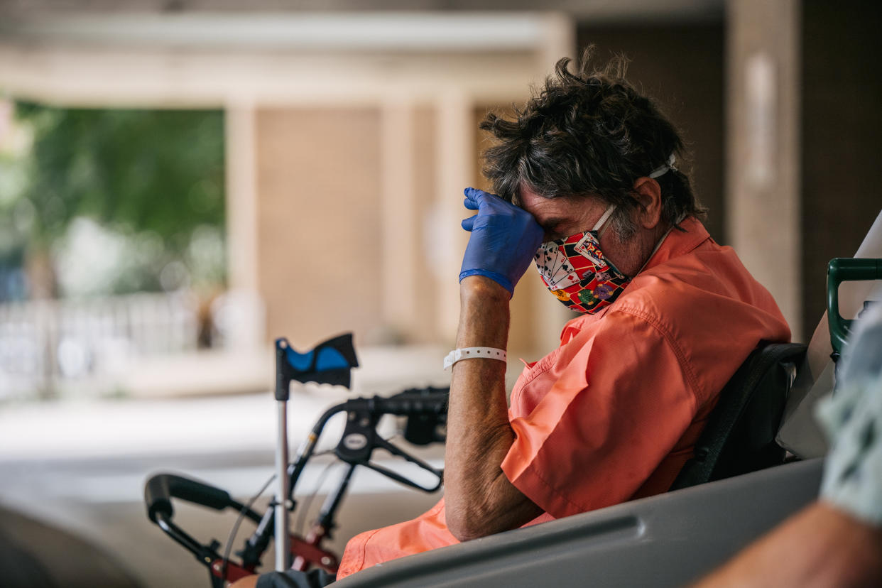 A man sits with his head down while waiting to depart the Houston Methodist Hospital on July 16. (Brandon Bell/Getty Images)