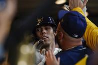Milwaukee Brewers' Christian Yelich is congratulatedf in the dugout after hitting a home run during the first inning of a baseball game against the Arizona Diamondbacks Monday, Oct. 3, 2022, in Milwaukee. (AP Photo/Morry Gash)