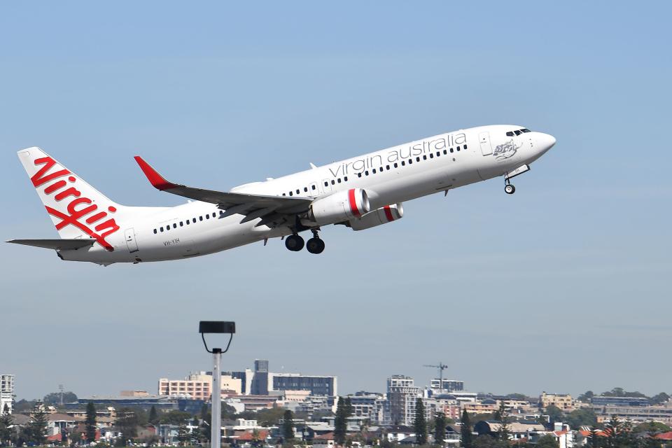 A Virgin Australia plane takes off at Sydney Airport in Sydney on March 19, 2020. - Australia's biggest airline Qantas said it would halt all international flights and suspend 20,000 staff in response to the coronavirus pandemic, days after the island nation's other main carrier Virgin shut its overseas routes. (Photo by Saeed KHAN / AFP) (Photo by SAEED KHAN/AFP via Getty Images)