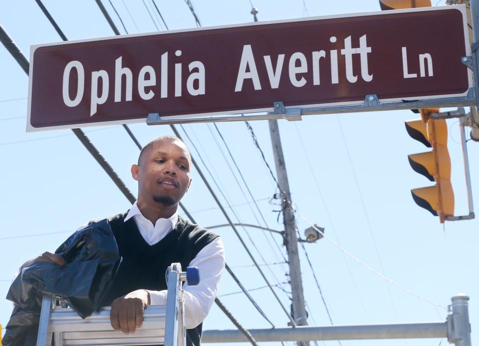 Darian Johnson, 31 unveils the street sign designating the corner of Frederick Boulevard and Copley Road as Ophelia Averitt Lane.