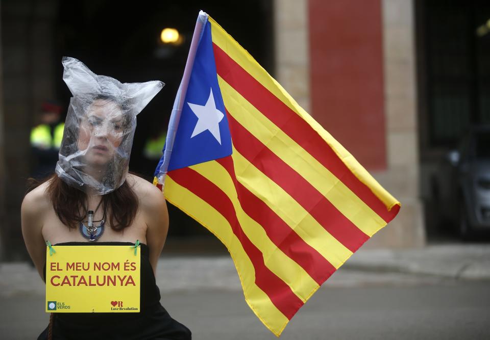 A pro-independence protestor sits in front of Catalonia's regional parliament as lawmakers voted inside, in Barcelona