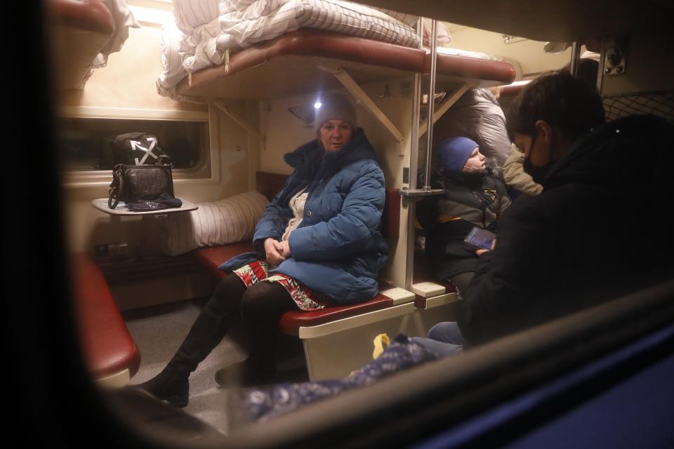 People from Donetsk and Luhansk regions, the territory controlled by a pro-Russia separatist governments in eastern Ukraine, sit a train carriage waiting to be taken to temporary residences in the Volgograd region, at the railway station in Volzhsky, Volgograd region, Russia, on Sunday, Feb. 20, 2022. Ukrainian President Volodymyr Zelenskyy, facing a sharp spike in violence in and around territory held by Russia-backed rebels and increasingly dire warnings that Russia plans to invade, has called for Russian President Vladimir Putin to meet him and seek a resolution to the crisis. (AP Photo/Alexandr Kulikov)