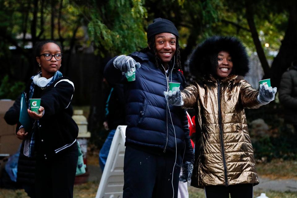 Volunteers from Cass Tech High School students offer water for marathon runners in the Woodbridge neighborhood during the 45th Annual Detroit Free Press Marathon in Detroit on Sunday, Oct. 16, 2022.