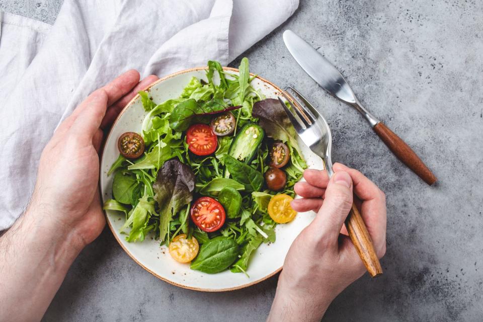 man eating vegetarian vegetables healthy salad with red and yellow