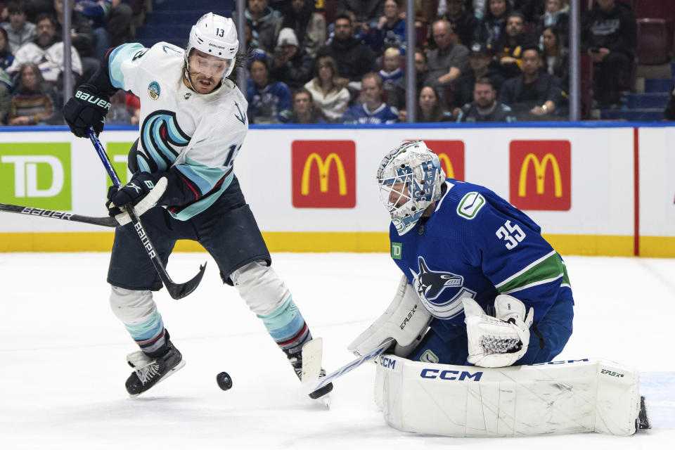 Seattle Kraken's Brandon Tanev (13) tries to tap in a shot against Vancouver Canucks goaltender Thatcher Demko (35) during the first period of an NHL hockey game Saturday, Nov. 18, 2023, in Vancouver, British Columbia. (Ethan Cairns/The Canadian Press via AP)