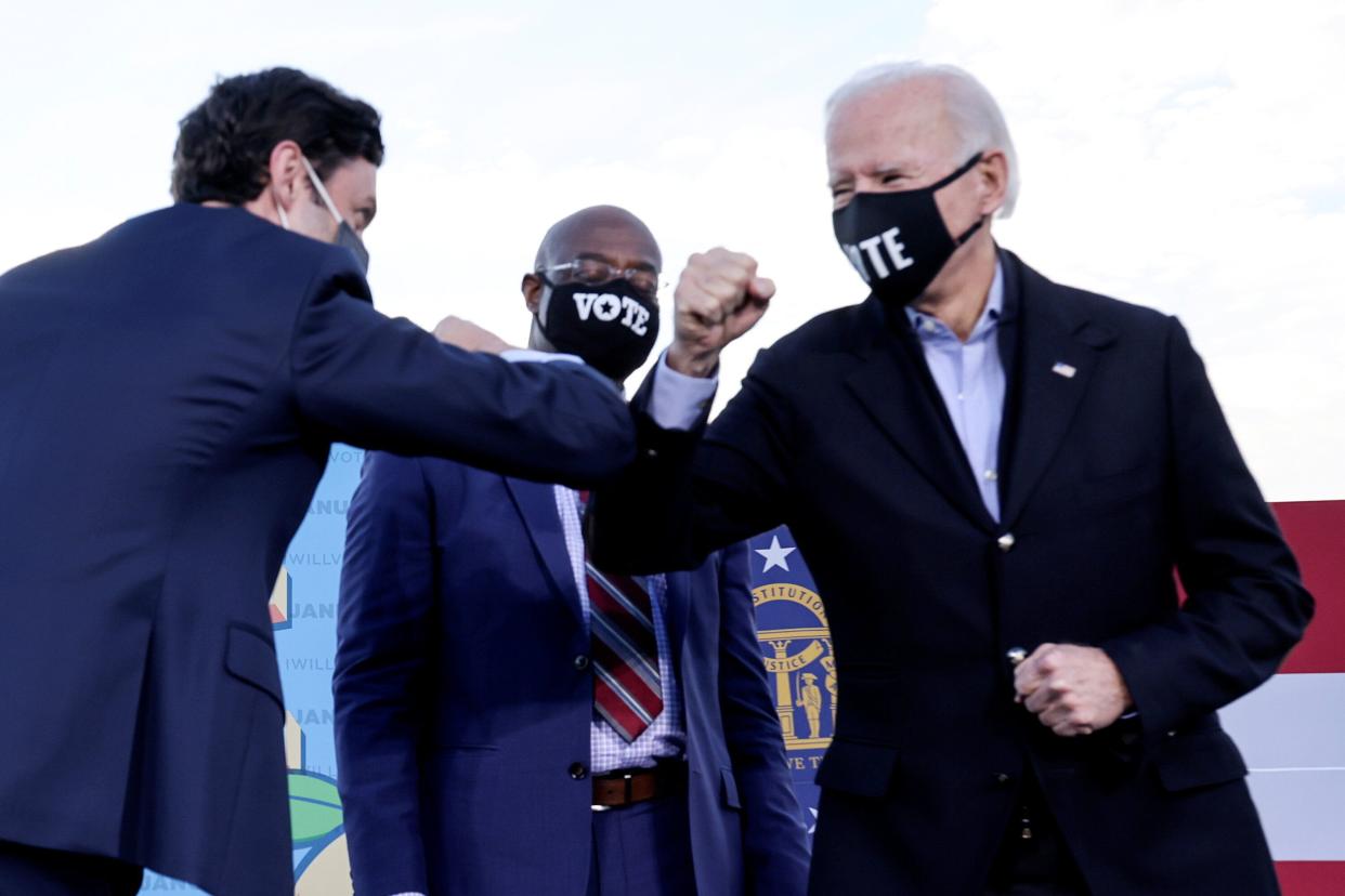 President Joe Biden, right, and Sens. Jon Ossof, left, and Rev. Raphael Warnock, newly elected in Georgia, promised voters $2,000 checks. What that promise meant is the subject of debate. (Photo: Jonathan Ernst/Reuters)