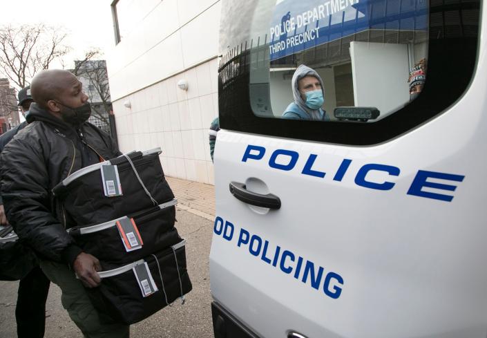 Sgt. Lacell Rue helps to pack Detroit police vehicles with baskets of meals to be distributed from the Third Precinct in Detroit Wednesday, Dec. 23, 2020. The Detroit Public Safety Foundation (DPSF) received a generous donation from the A.A. Van Elslander Foundation for the purchase of food for families on Detroit's East side.