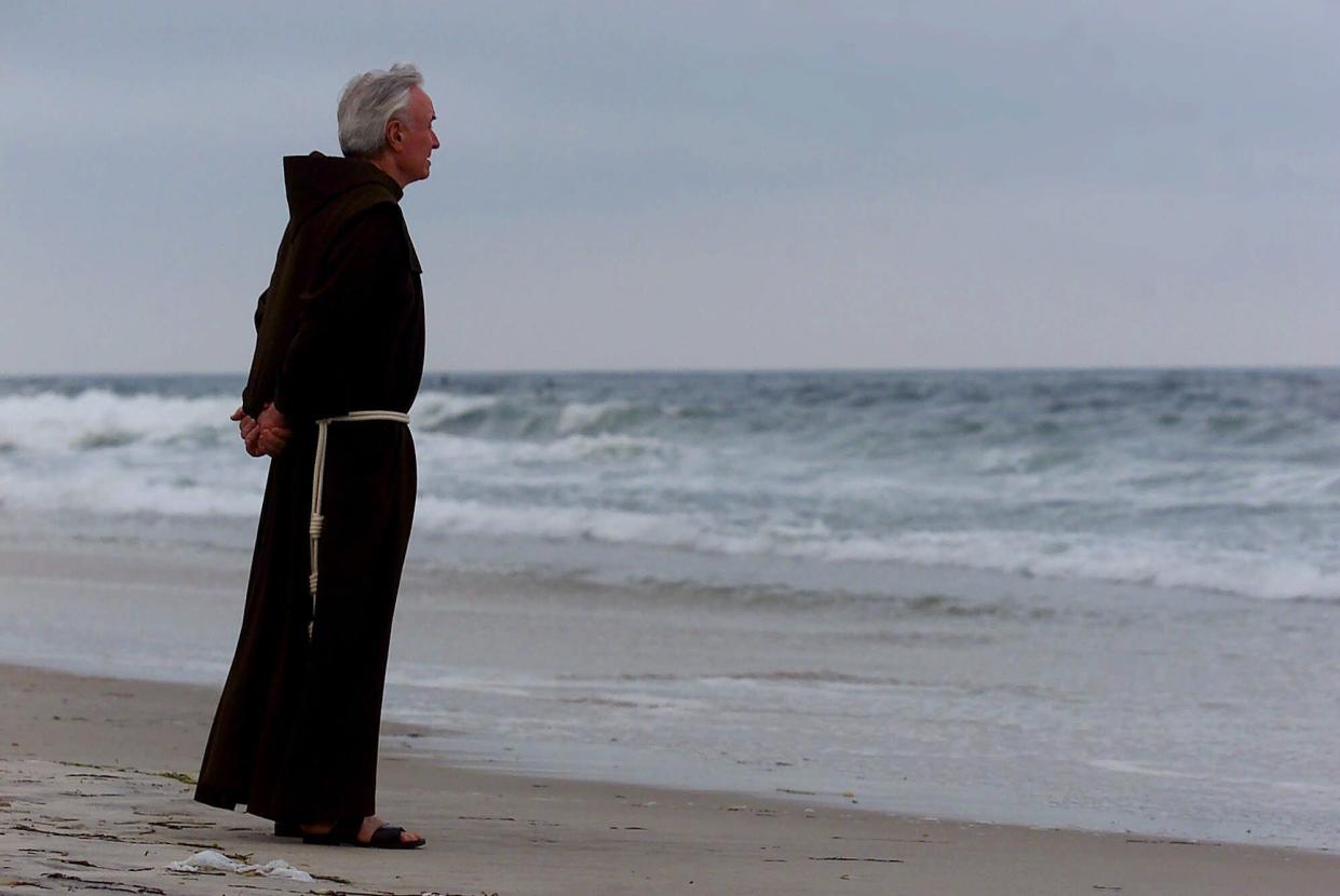 Rev. Mychal Judge, the FDNY's chaplain, stands at the shore before a service to remember the victims of TWA Flight 800, on July 17, 2000 at Smith Point Park in Shirley, N.Y. 