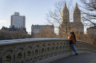 A visitor basks in the sunlight on the Bow Bridge in Central Park, Monday, Jan. 30, 2023, in the Manhattan borough of New York. Since the start of winter in December, there hasn't been any measurable snowfall in the city. The last time it took this long before snow lingered on the ground in the wintertime was 1973, when New Yorkers had to wait until Jan. 29. (AP Photo/John Minchillo)