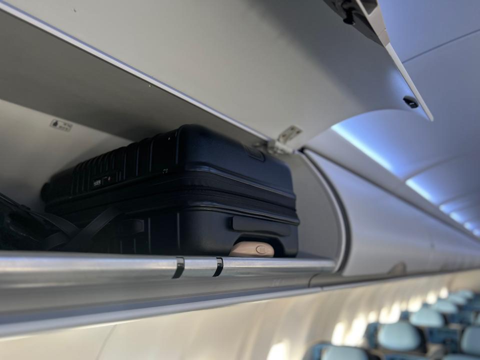 Flying on La Compagnie all-business class airline from Paris to New York — my carry-on bag and my backpack in the overhead bin above row number 14.