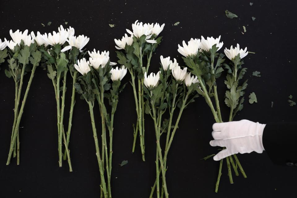 A woman holds flowers as she pays tribute at memorial altar for the victims of the Halloween celebration stampede, in front of City Hall on 31 October 2022 in Seoul, South Korea (Getty Images)